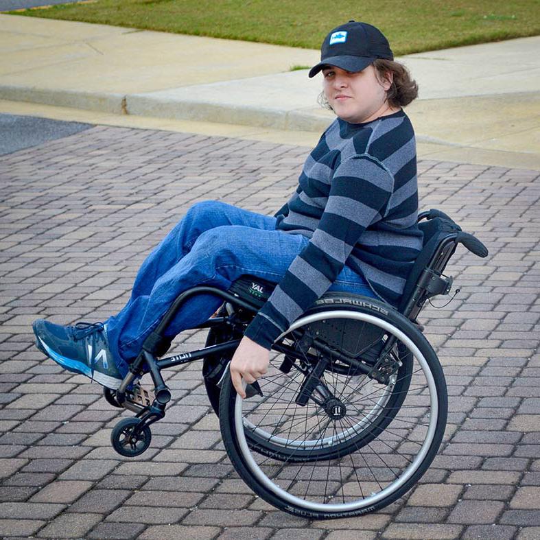 一个坐在轮椅上的学生在校园里穿行